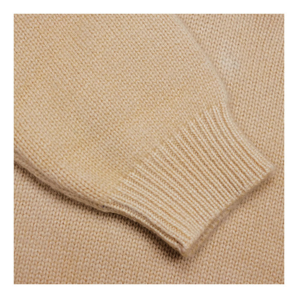 Close up of sleeve ribbing detail. Sweater in cosy camel
