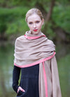 Model wearing scarf in camel beige blended with cream scarf with light pink stripe 2cm wide down both edges. As featured in The Sunday Times luxurious scarf from Thread Tales company