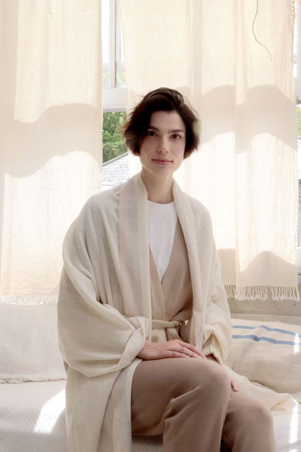 Model is wearing a cocooning meditation wrap delicately handwoven in eri silk and cashmere.