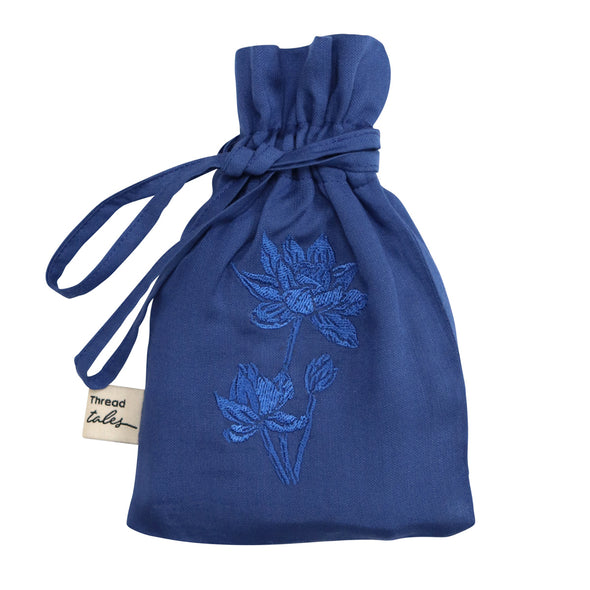 Midnight blue silk pouch embroidered with blue lotus flower containing eye mask