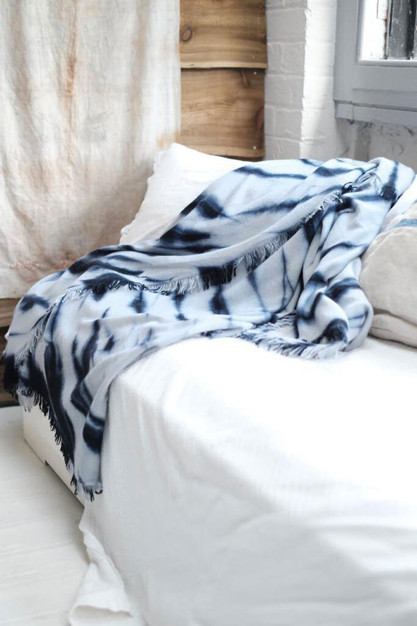 Beautiful tie dye wool and cashmere blanket draped over sofa to add luxury to home accessories