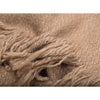 Folded fringe detail of 100% camel wool luxurious oversized blanket wrap in camel colour with cream selvedge edge stripe. Soft and thick this cosy travel wrap is from Thread Tales company