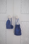 Midnight blue Lotus silk eye mask with matching blue lotus silk pouch hanging on vintage cupboard door