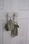 Lotus silk eye mask and matching pouch hanging from white bathroom door